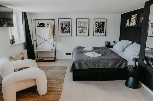 een zwart-witte slaapkamer met een bed en een stoel bij sleepArt Black&White in Celle