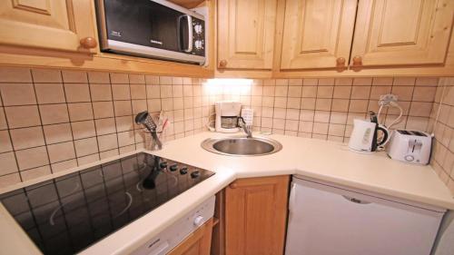 une petite cuisine avec un évier et un micro-ondes dans l'établissement Résidence Dame Blanche - DBA103 - APPT 2 CHAMBRES - BALCON - 6 PERSONNES - Secteur 1800 MAE-5171, à Narreyroux
