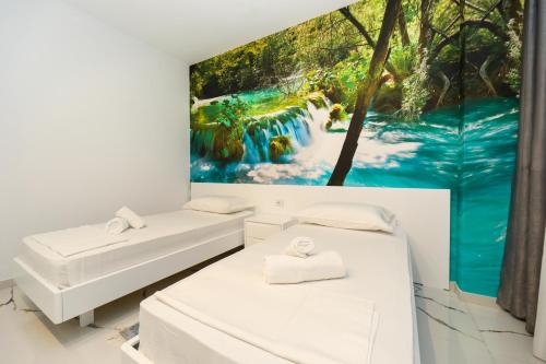 duas camas num quarto com um quadro na parede em Tesi Apartment em Vlorë