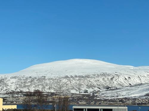 a mountain covered in snow with a city at Polar Arctic Luxury House - Free parking in Tromsø