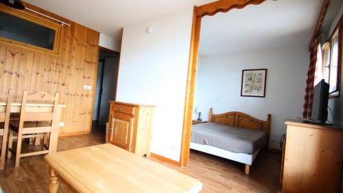 uma sala com um quarto com uma cama e um espelho em Résidence Dame Blanche - 2 Pièces pour 6 Personnes 181 em Narreyroux