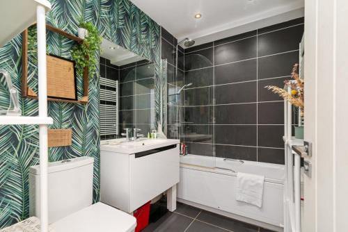 een badkamer met een bad, een wastafel en een douche bij GuestReady - Artsy Penthouse in Heart of the City in Londen