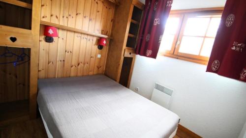 une chambre avec un lit dans une pièce aux murs en bois dans l'établissement Résidence Dame Blanche - DBAC21 - APPT 2 CHAMBRES - BALCON - 6 PERSONNES - Secteur 1800 MAE-5201, à Narreyroux