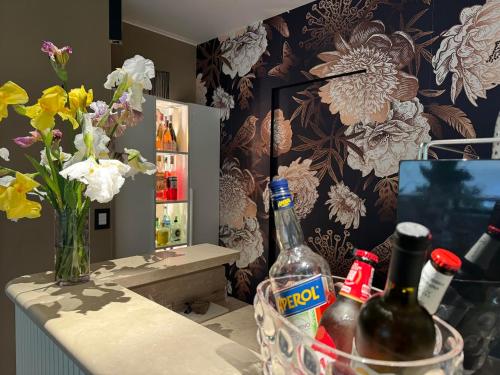 a counter with bottles of wine and a vase of flowers at Hotel Clodia - Adults Only in Sirmione