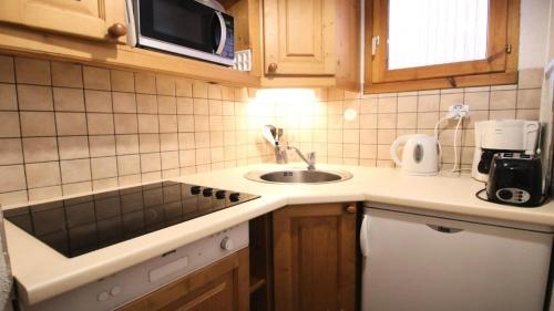 une petite cuisine avec un évier et un micro-ondes dans l'établissement Résidence Dame Blanche - DBA215 - APPT 1 CHAMBRE + CABINE - BALCON - 6 PERSONNES MAE-5191, à Narreyroux