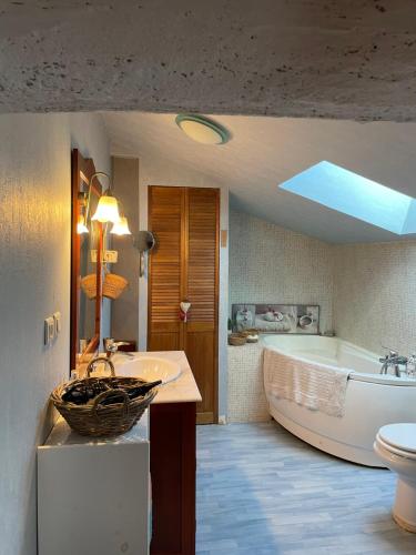 ein Badezimmer mit Badewanne, Waschbecken und Toilette in der Unterkunft Chambres à la campagne in Sauveterre