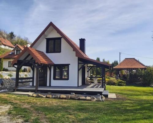a small white house with a roof at Osada wspomnień in Polańczyk