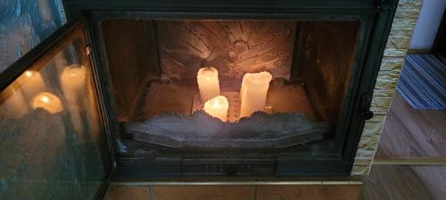 a candle in a fireplace with lights in it at Spokojne i miłe miejsce na Mazurach in Kętrzyn