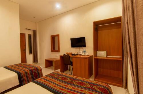 a hotel room with a bedroom with a bed and a desk at Diva Lombok Resort in Senggigi 