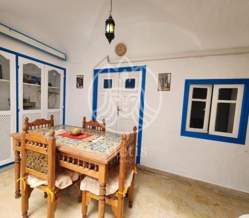 a dining room with a wooden table and chairs at medina hammamet in Hammamet