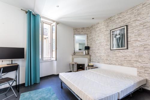 une chambre avec un lit et un mur de briques dans l'établissement Les Suisses Apartment Zentral in der schönen Altstadt von Le Suquet 5 min zum Strand WLAN, à Cannes