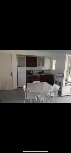 une cuisine avec une table blanche et des chaises dans l'établissement Villa Chrispas, à Cavalaire-sur-Mer