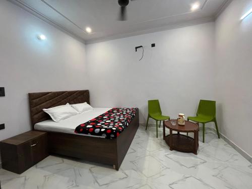 a bedroom with a bed and two green chairs at Vinayak Homestay in Mathura