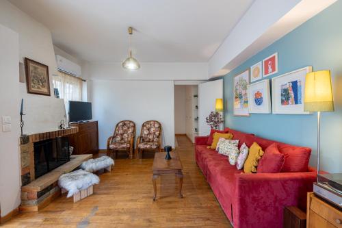 - un salon avec un canapé rouge et une cheminée dans l'établissement Lemon Tree House, à Vrahati