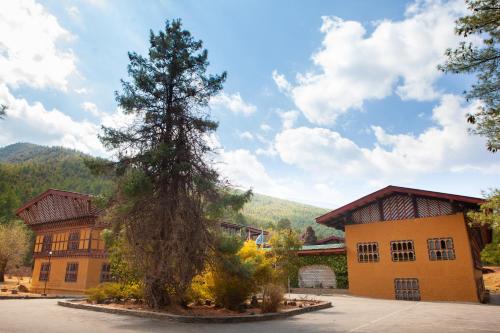 a large building with a tree in front of it at Hotel Olathang in Paro