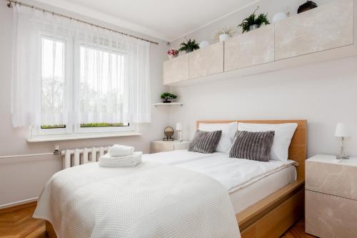 um quarto branco com uma cama grande e uma janela em Seaside Apartment with the View em Gdynia