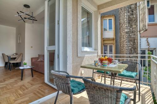 a room with a balcony with a table and chairs at Apartments Elena in Budva