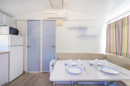 a kitchen with a white table and a refrigerator at Móvil Home Grande in Alós de Balaguer