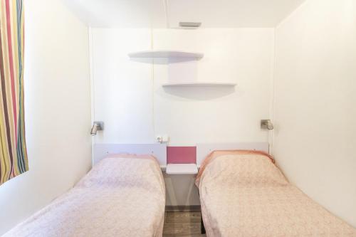 two beds in a small room with white walls at Móvil Home Grande in Alós de Balaguer