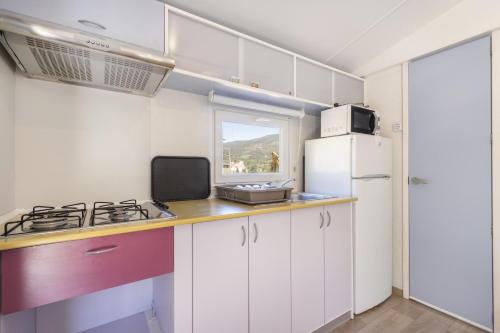 a kitchen with white cabinets and a white refrigerator at Móvil Home Grande in Alós de Balaguer