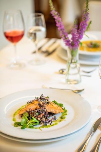 a plate of food on a table with wine glasses at Hotel Radun in Luhačovice