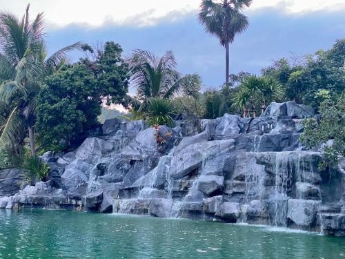 uma cascata em frente a uma piscina de água em ช่องแคบ เดอ เมาท์เท่น รีสอร์ท em Ban Huai Nam Nak