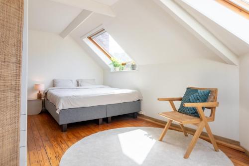 ヘントにあるGuesthouse private studio nearby old town Ghentのベッドルーム1室(ベッド1台、屋根裏部屋の椅子付)