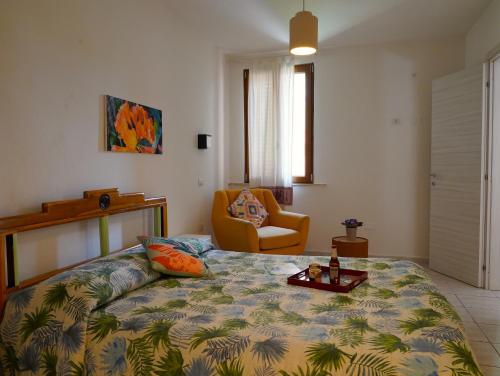 a bedroom with a bed and a chair at Flowery Inn Villa in Alghero