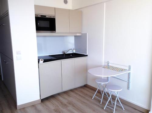 - une petite cuisine avec une table et deux tabourets dans l'établissement studio avec magnifique vue mer a Carnon-plage, à Carnon-Plage