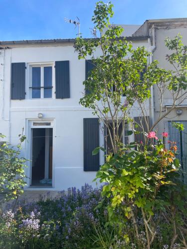 a white house with black shutters at Maison totalement renovée in La Rochelle