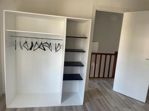 a white closet with a rack of shoes at Maison totalement renovée in La Rochelle