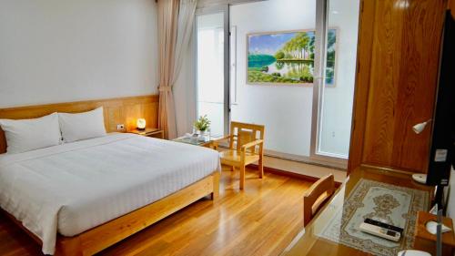 a hotel room with a bed and a window at Blue Hanoi Hotel in Hanoi