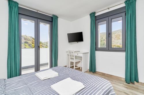 a bedroom with a bed and a desk and windows at Era del Puerto 1 in Tolatán