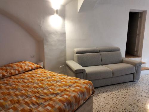 a bedroom with a bed and a couch and a chair at Stone Rooms in Matera