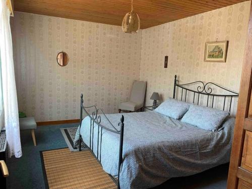 une chambre avec un lit et une chaise dans l'établissement Agréable ancienne maison de ville, au Château-dʼOléron