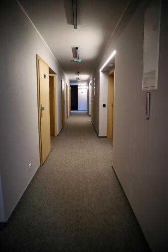 an empty hallway in an office building with doors and carpet at Hotel Bastion in Malbork