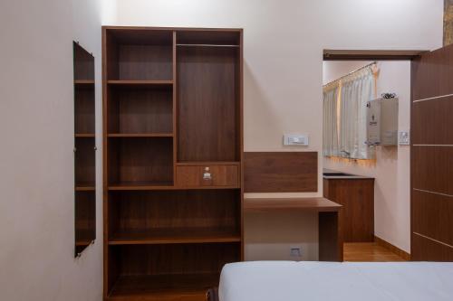 um quarto com prateleiras de madeira e uma cama em MUGUNDAN 'S SMART STAY em Coimbatore