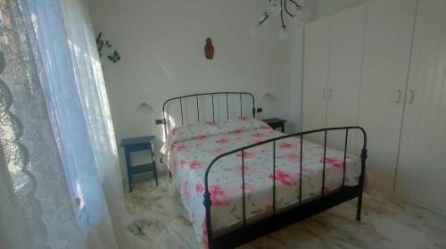 - une chambre avec un lit orné de fleurs roses dans l'établissement Casa Chantal, à Fiumaretta di Ameglia