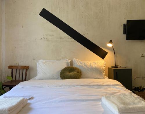 - un grand lit blanc avec un oreiller dans l'établissement Capsula, à Tbilissi