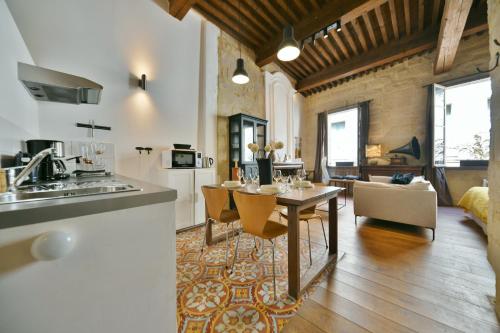 een keuken en een woonkamer met een tafel en stoelen bij "La Suite" 3 Etoiles in Uzès