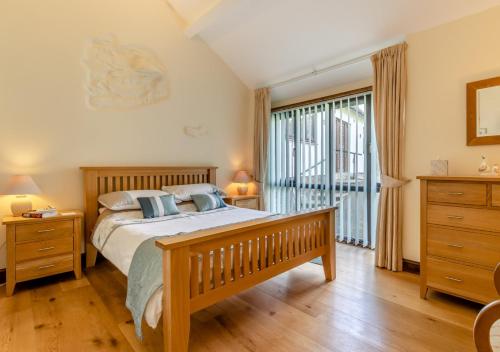 a bedroom with a bed and a large window at 2 Derw Cottages in Trefeglwys