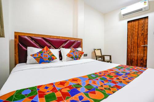 una camera con un grande letto e una trapunta colorata di FabExpress Akshay a Mumbai