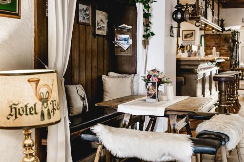 Zimmer mit einem Tisch, Stühlen und einer Theke in der Unterkunft Hotel Post Abtenau in Abtenau