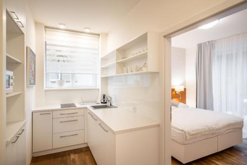 a white kitchen with a sink and a bed at Vila EVA in Luhačovice