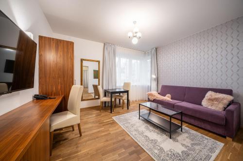 a living room with a purple couch and a table at Vila EVA in Luhačovice