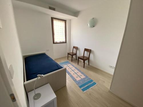 Habitación con cama, 2 sillas y ventana en Casa Martinelli, en Nago-Torbole