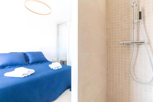 - une chambre avec un lit bleu et une douche dans l'établissement Villa Abalone - Propriété d'Exception, à Sanary-sur-Mer