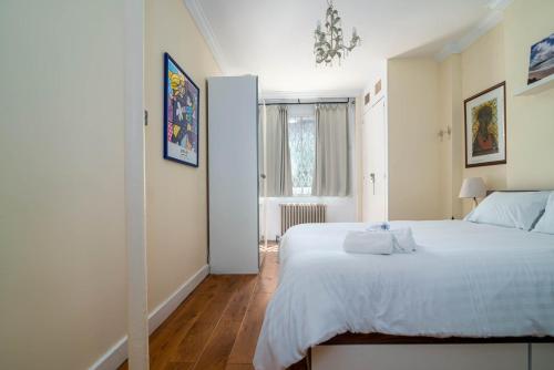 sypialnia z dużym białym łóżkiem i oknem w obiekcie GuestReady - Former Pub-Turned-One Bedroom Flat w Londynie