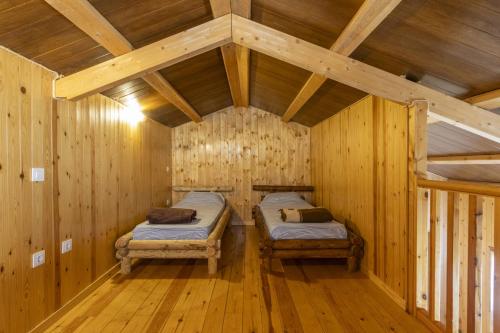 a room with two beds in a wooden cabin at Bungalow Alós in Alós de Balaguer