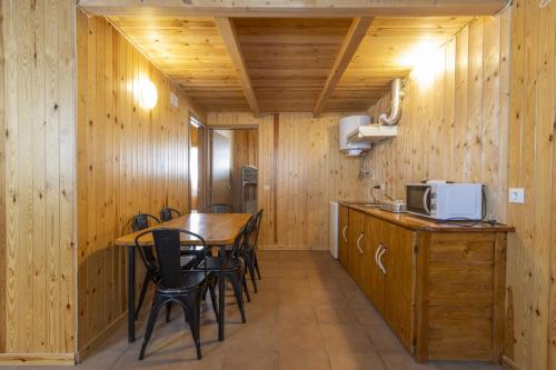 a kitchen with wooden walls and a table and chairs at Bungalow Alós in Alós de Balaguer